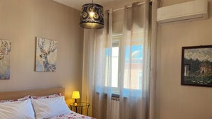 Ein Hotelzimmer mit Bett, Lampe, einem Bild und einer Klimaanlage.