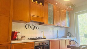 Eine Küche mit Holzausstattung, einem Gasherd, einem Backofen und einer Spritzschutzleiste mit dem Schriftzug 'Cuisinart'.
