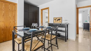 A dining area with a glass table, black chairs, and a dark cabinet. - Homely Lanzarote (Arrecife)