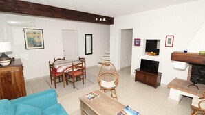 A living room with a sofa, a dining table with chairs, a television, and a fireplace. - Villa 6p sea view all comfort beach accessible on foot! (Grosseto-Prugna)