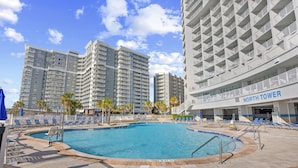 Zona de piscina con sillones de descanso y un edificio identificado como "North Tower".