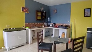 Una cocina compacta con comedor, refrigerador y dispensador de agua.
