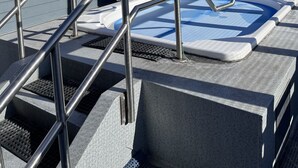 Área de hidromassagem com grades de metal e vista para montanhas cobertas de neve ao fundo.