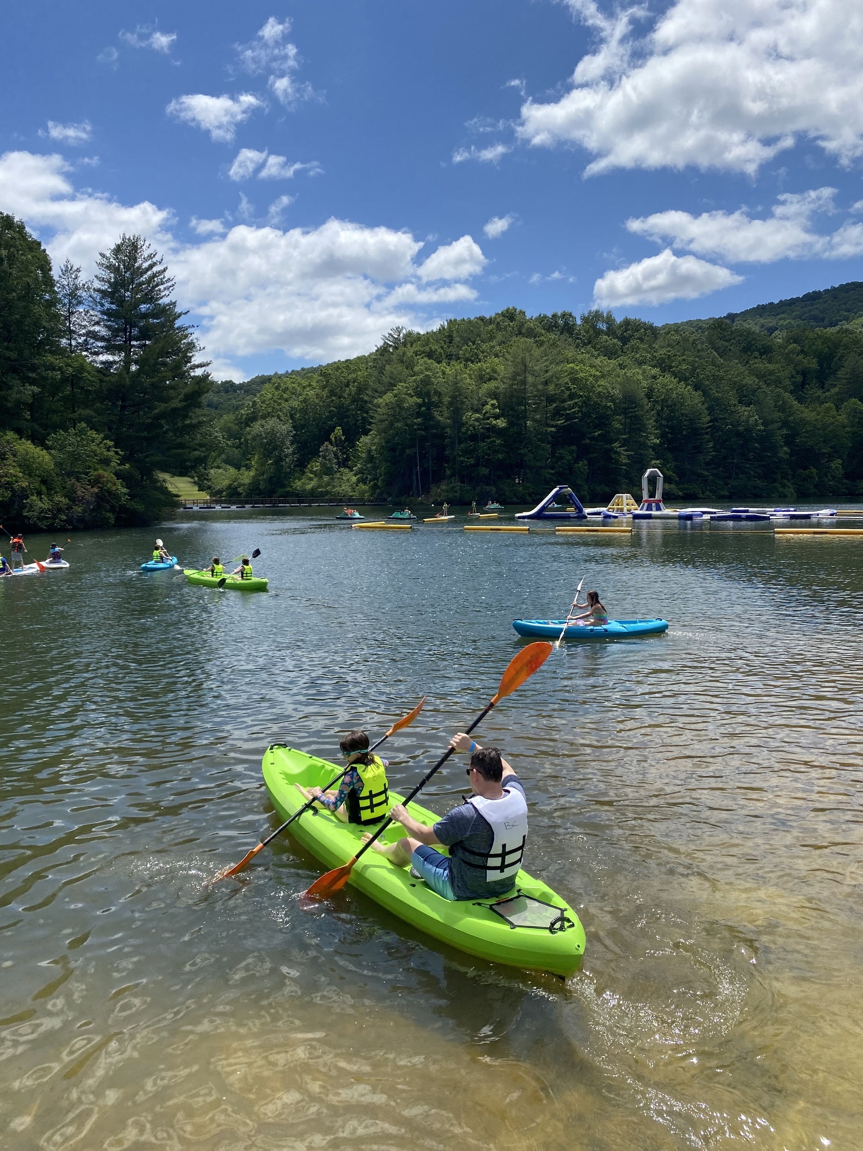 Un lago tranquillo con kayak e un piccolo molo.
