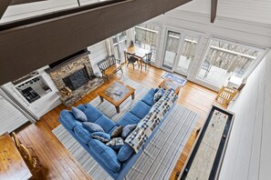 Ein geräumiges Wohnzimmer mit blauem Sofa, Holztisch und Kamin.
