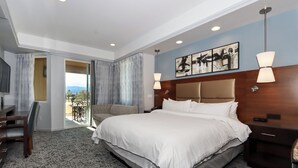 Une chambre d’hôtel avec un grand lit, un bureau et une vue sur l’extérieur.