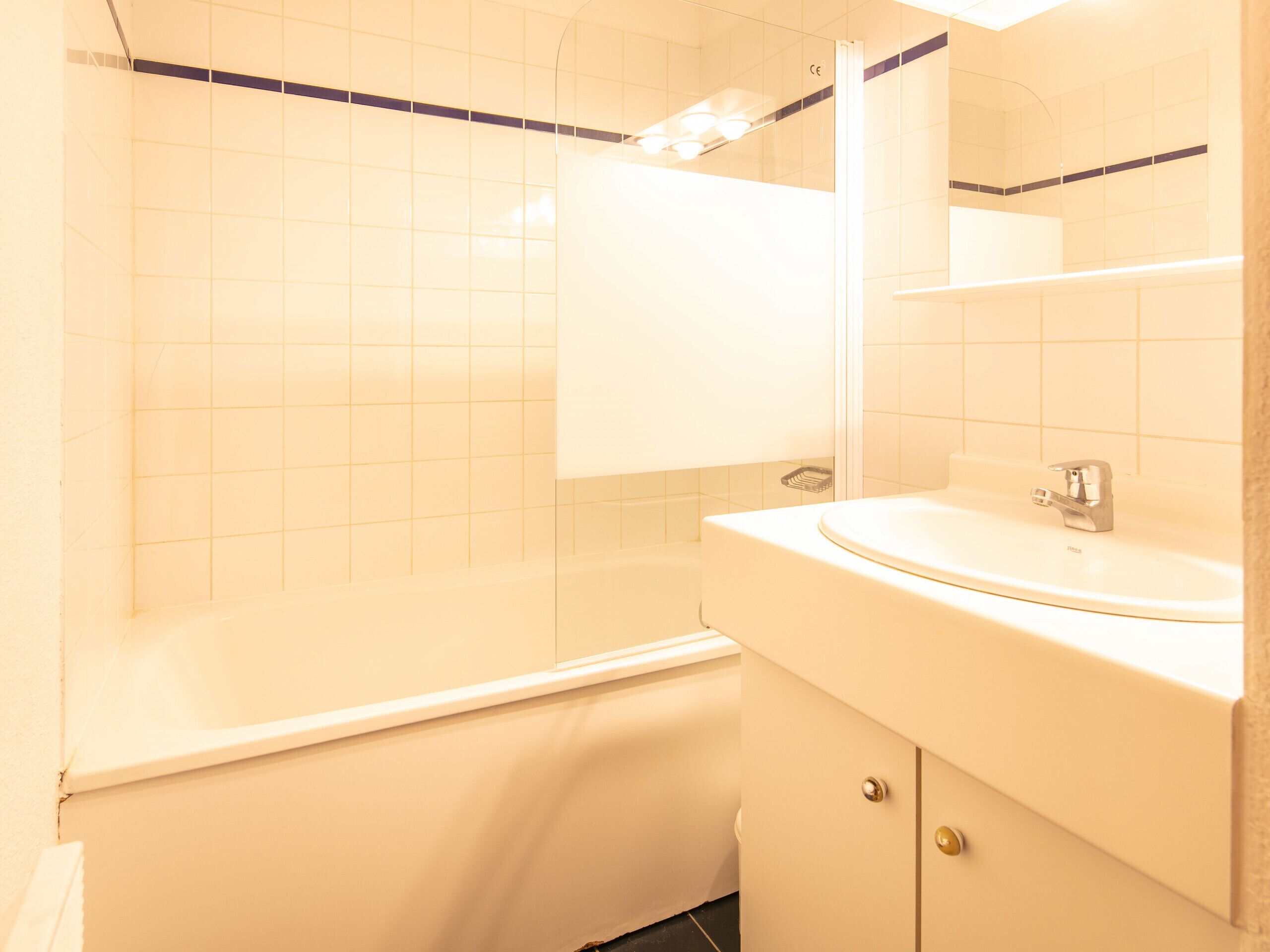 Une salle de bain avec une baignoire, un lavabo et un miroir.