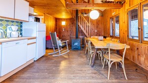 Un intérieur en bois comprenant une cuisine, un coin repas et une cheminée.