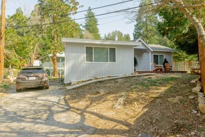 A single-story house with a front porch, a garage, and a driveway. - Modern Crestline Cabin Near Creek & Lake Gregory (Crestline)