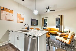 Enjoy cooking and relaxing in this well-equipped kitchen and living area with a sofa, coffee table, and flat-screen TV.
