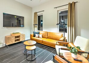 Relax in this inviting living room with a sofa, chair, and sideboard, perfect for unwinding with a TV and a view.