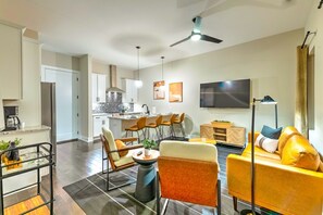 Relax in this stylish living area with a sofa, chairs, and TV, perfect for unwinding. Enjoy meals at the dining table and kitchen counter.
