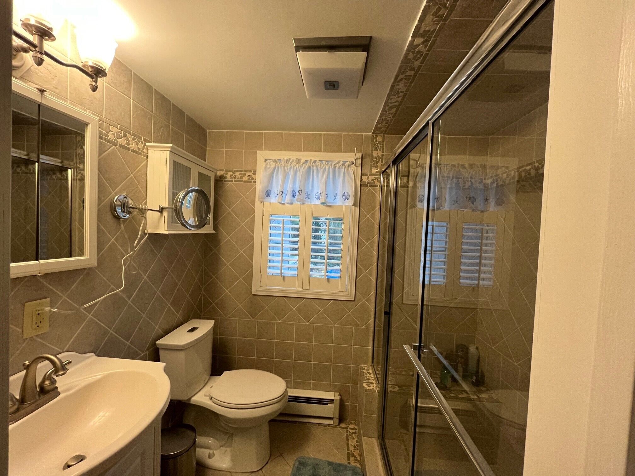Een badkamer met wastafel, toilet en douche.