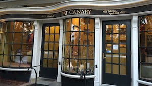 Het uiterlijk van een gebouw met een bord waarop staat 'FAT CANARY' en 'rijke Palermo, sprankelende sherry'.