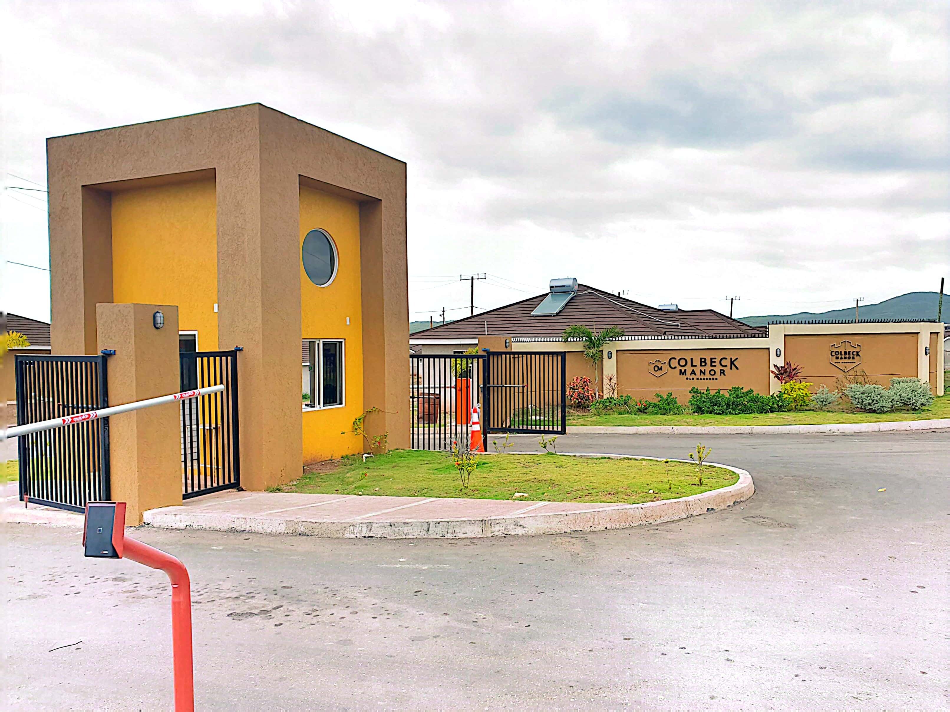 A gated entrance with a yellow building labeled "Colbeck Manor."