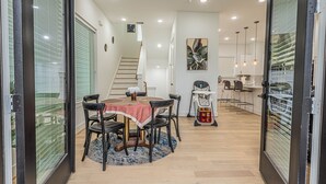 Una cocina moderna con comedor, una escalera y cambiador para bebés.