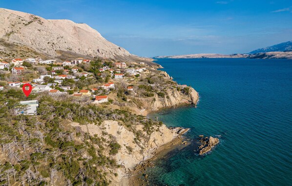 Un pueblo costero con casas en una ladera con vistas al mar.