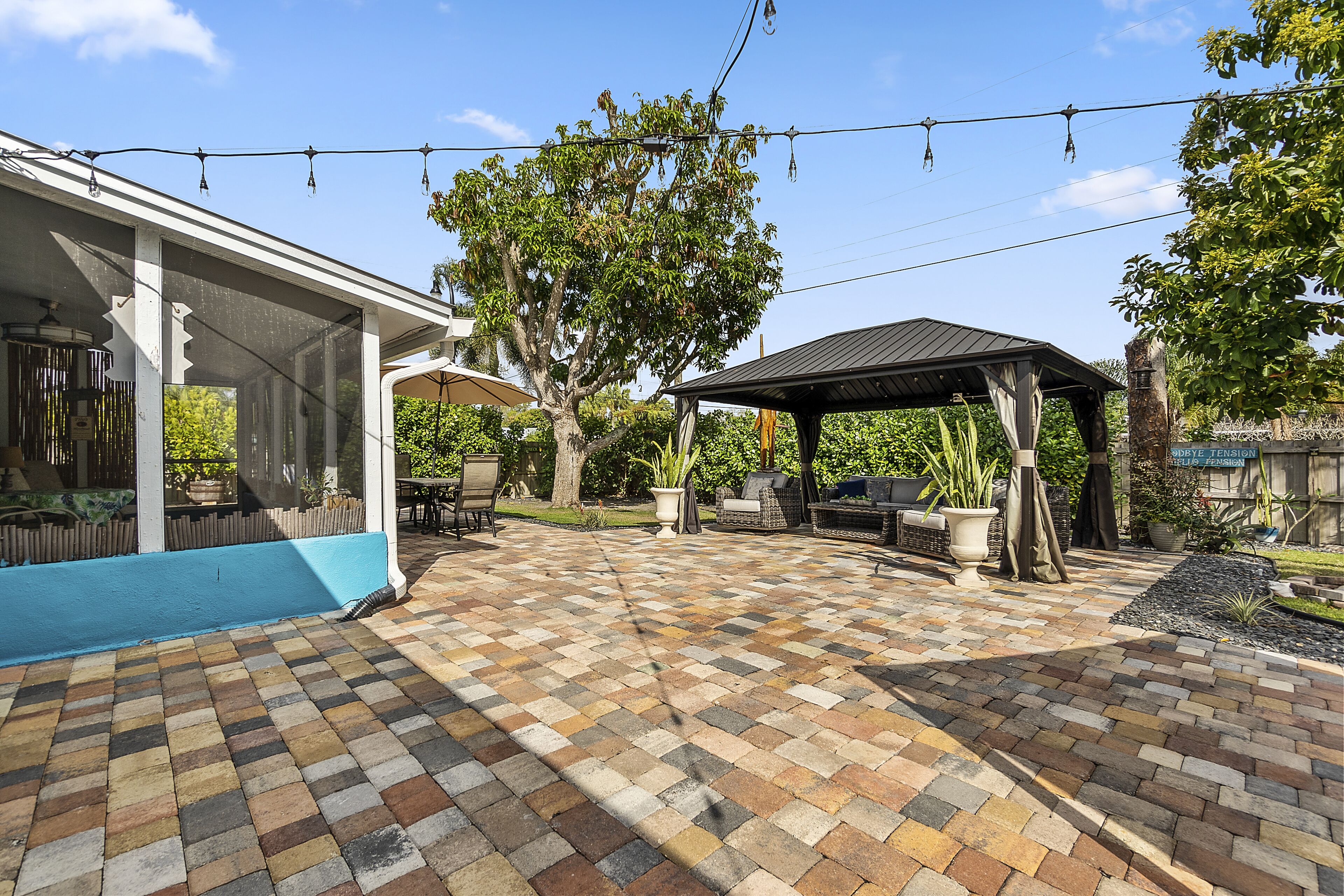 A patio area with a checkered tile floor, a covered seating area, and a pergola.