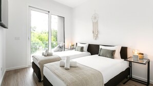 A modern bedroom with two beds, a large window, and a dreamcatcher on the wall. - Sea & Sun Apartment - Pool with Sea View (Nazaré)