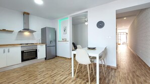 A modern kitchen with a built-in oven, a stainless steel refrigerator, and a dining area with a white table and chairs. - 3 bedroom stunning home in Ador (Ador)