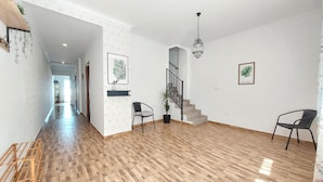 A spacious living area with wooden flooring, a staircase, and two chairs. - 3 bedroom stunning home in Ador (Ador)