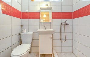 A small, modern bathroom with a toilet, sink, and shower. - Cozy apartment in Novalja with house sea view (Novalja)