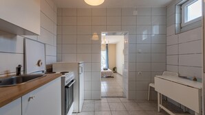 A modern kitchen with white cabinetry, a wooden countertop, and a built-in oven. - Cozy apartment in Novalja with WiFi (Novalja)