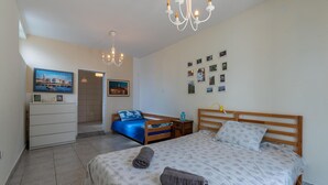 A bedroom with a large bed, a wooden headboard, a nightstand, a dresser, and a chandelier. - Cozy apartment in Novalja with WiFi (Novalja)