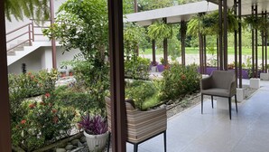 A covered outdoor area with a staircase, potted plants, and a chair. - Nature rich home environment, minutes away from all state parks and beach towns. (Cahuita)