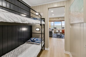 A bunk bed room with a view of the beach through an open door. - [Amazing gulf views, 1 BR+bunkroom, free beach chairs, walk to Pier Park] (Panama City Beach)