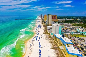 A coastal cityscape with a beach, high-rise buildings, and a pier. - [Amazing gulf views, 1 BR+bunkroom, free beach chairs, walk to Pier Park] (Panama City Beach)
