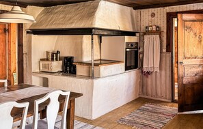 A compact kitchen with a microwave, coffee maker, and oven. There is a wooden table with chairs and a rug on the floor. - 2 bedroom nice home in Bredaryd (Bredaryd)