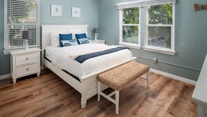 A bedroom with a bed, bedside tables, a bench, a ceiling fan, and a window with blinds. - Single-family PB house, 1 Block to Beach (San Diego)