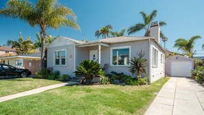 A single-story house with a front porch, a garage, and a well-maintained lawn. - Single-family PB house, 1 Block to Beach (San Diego)