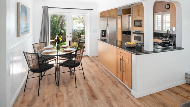 A modern kitchen with wooden cabinets, a black countertop, and a stainless steel refrigerator. - Single-family PB house, 1 Block to Beach (San Diego)