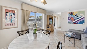 A modern living room with a dining area, a ceiling fan, a TV, and artwork on the walls. - 6 Ocean views, direct beach access Sunset Cove Laguna BCH (F) (Laguna Beach)