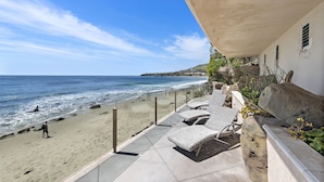 A beachside patio with lounge chairs, a view of the ocean, and a rocky landscape in the background. - 6 Ocean views, direct beach access Sunset Cove Laguna BCH (F) (Laguna Beach)