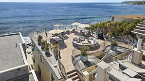 Une terrasse sur le toit avec des espaces de détente en plein air, une piscine et une vue sur la mer.