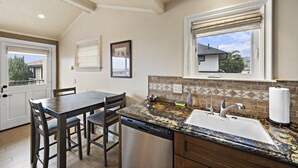 A kitchen with a granite countertop, stainless steel dishwasher, and a window with a view of the outside. - Swim, bike, relax, explore Laguna Beach 3 Villa D'Arte (Laguna Beach)