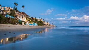 A beachfront property with multiple-story houses, a sandy beach, and a calm sea. - Ocean View Villa, walk to main beach, easy beach access (Laguna Beach)