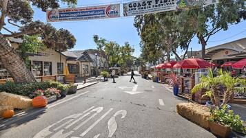 Eine Straße mit einem Schild für das Coast Film and Music Festival, Heuballen und Topfpflanzen.