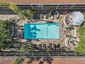 Relax by the pool surrounded by lush greenery and shaded seating areas.