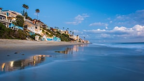 A beach with houses on a hillside, a calm sea, and a clear sky. - Ocean views steps to the water prime Laguna Beach 8 Villa Roma (Laguna Beach)