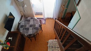 Un espace repas comprenant une table et des chaises, un escalier et une vue sur l’extérieur.