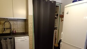 Une cuisine de taille réduite équipée d’un lave-vaisselle, d’un évier et d’un réfrigérateur.