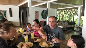 A group of people dining at a table with plates of food and drinks. - Reserva Natural Yavary Tucano (Leticia)