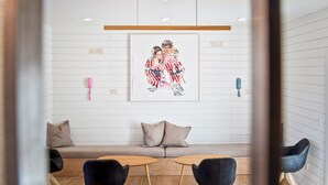 A modern interior with a sofa, two small tables, and a framed artwork on the wall. - Pet Friendly Boutique Hotel Room, Walk to Downtown | Rose Jean Room 5 (Charlottesville)