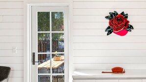 A room with a white door, a wooden table, and a red telephone. - Pet Friendly Boutique Hotel Room, Walk to Downtown | Rose Jean Room 5 (Charlottesville)