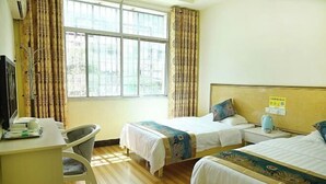 Ein Hotelzimmer mit zwei Betten, einem Schreibtisch und einem Stuhl.