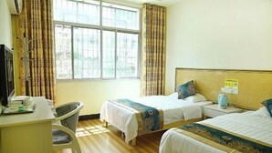 Ein Hotelzimmer mit zwei Betten, einem Schreibtisch und einem Stuhl.